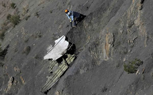 Un vigile del fuoco recupera un pezzo del velivolo - Foto Reuters
